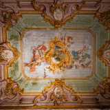 Ad accoglierci � un maestoso dipinto che occupa l�intera volta della prima stanza che visitiamo. I finti e raffinati elementi architettonici disegnati in prospettiva dilatano verso l�alto le reali dimensioni dell�ambiente